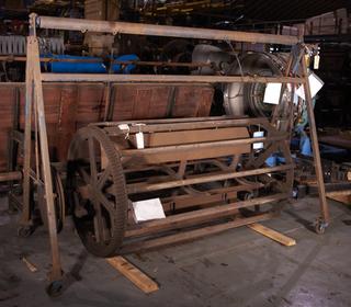 Cast iron A-shaped frame on wheels. Two cast iron bars align vertically underneath the top bar