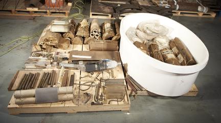 Parts of Reed papermaking machine in large white vat