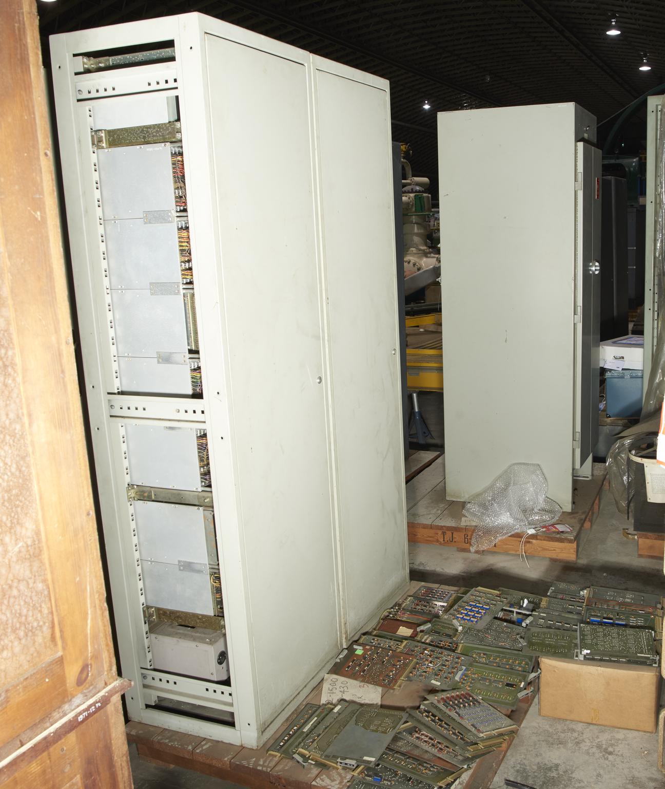 Two fixed racks of electronics and two boxes of PCB's (printed circuit boards)