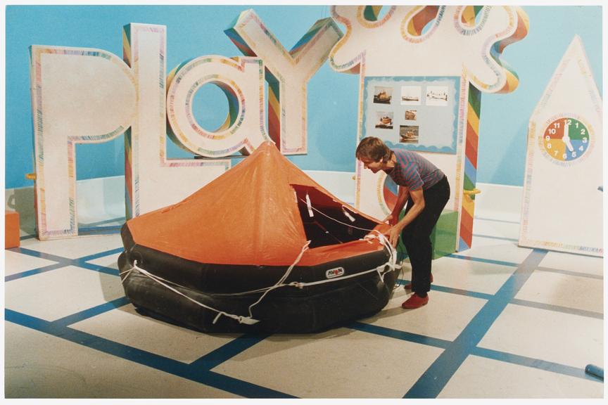 Photograph of presenter with an inflatable boat/tent and the