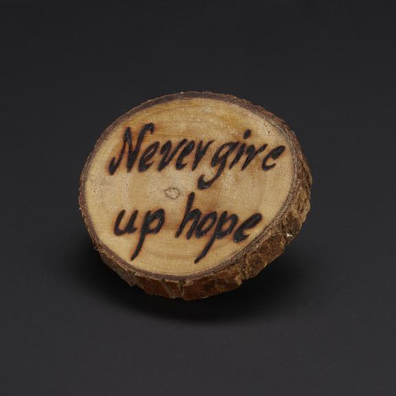 Small piece of wood inscribed �Never Give Up Hope�