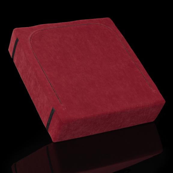 Red square cushion with two strips of Velcro on the back