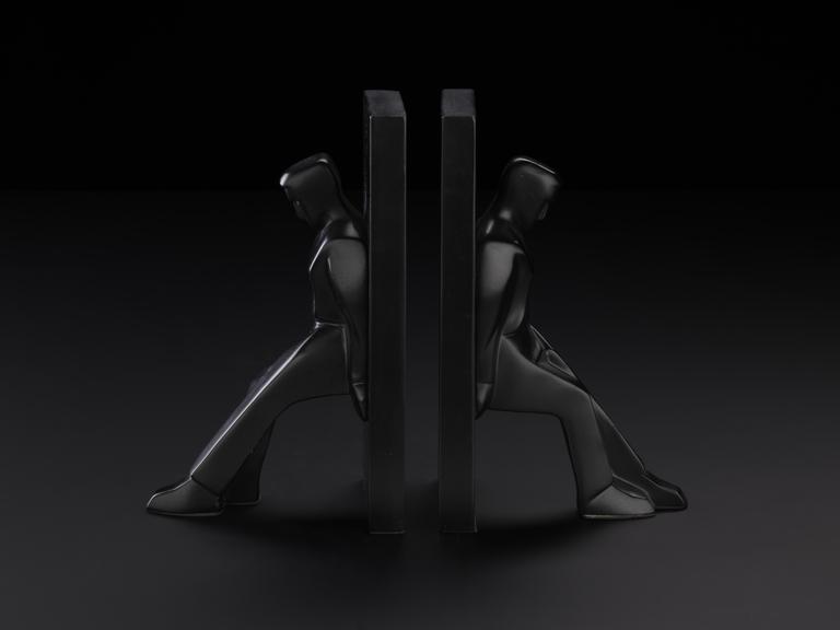 Black bookend of a figure leaning against a block. Designed by Chris Collicot for Kikkerland