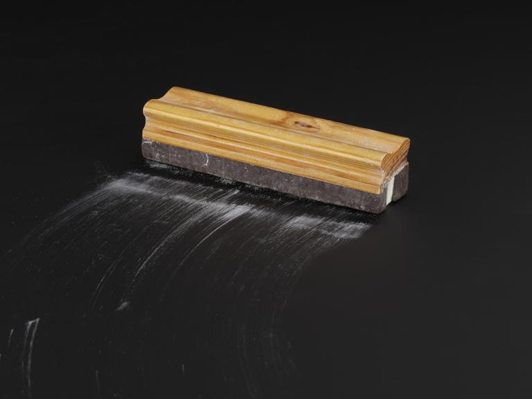 Wooden handled blackboard eraser stained with blue chalk