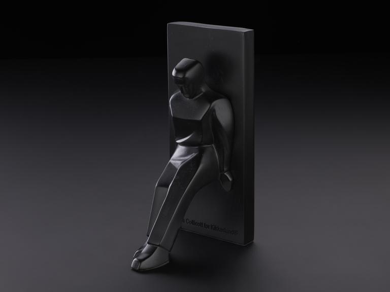 Black bookend of a figure leaning against a block. Designed by Chris Collicot for Kikkerland