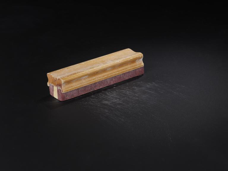 Wooden handled blackboard eraser stained with pink chalk