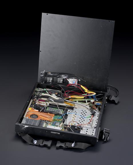 Computer in black enclosure. Enclosure includes sprung flaps covering ports and drives