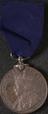 Silver medal attached to blue silk ribbon