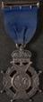 Silver prize medal with ribbon and claw brooch
