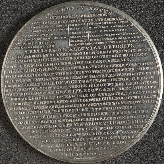 White metal medal with inscribed information on the subject of