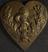 Heart-shaped brass badge showing caduceus inside foliate pattern