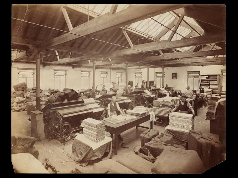 Photograph of Simpson and Godlee employees inspecting and packing cloth