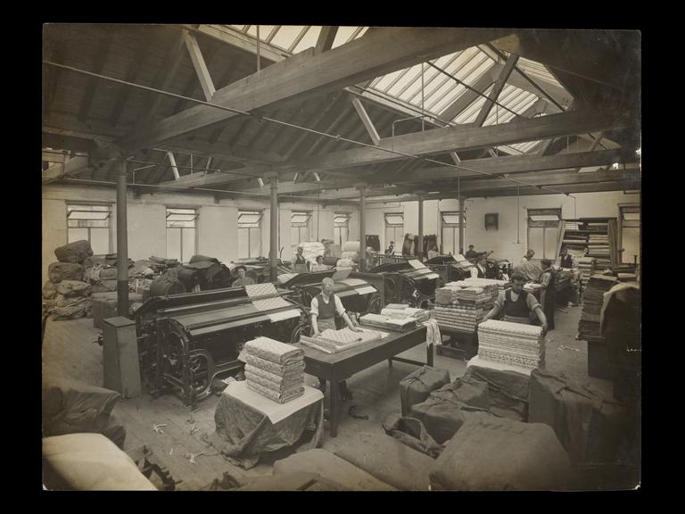 Photograph of Simpson and Godlee employees inspecting and packing cloth