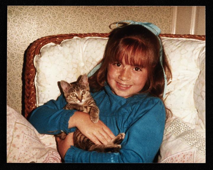 Photograph of a child with a kitten