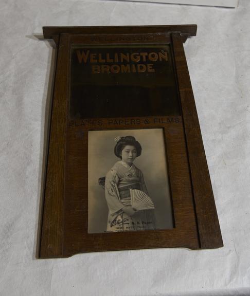 Hanging advertisement for Wellington Bromide, Plates, Papers etc