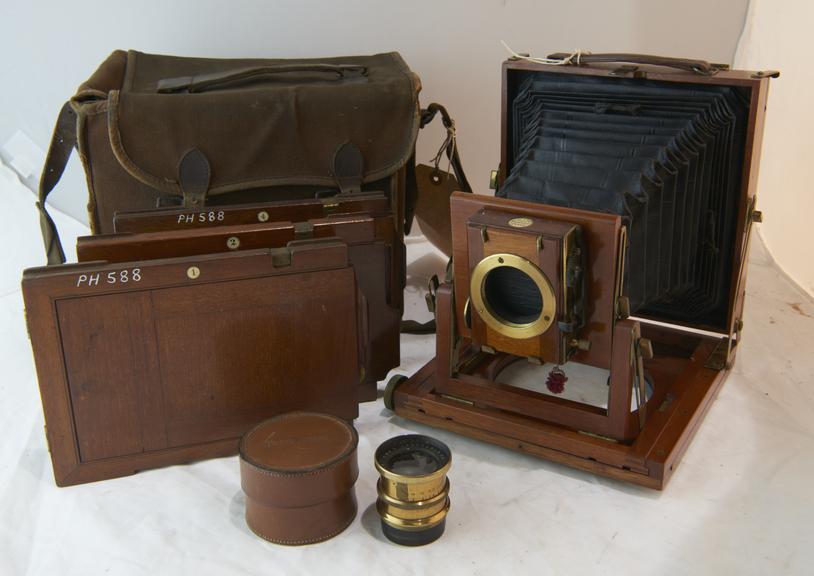 Folding Bellows Field and Stand Camera, Satchel, Three Bookform Double Darkslides and a Lens and Case.