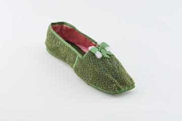 One moth-eaten green tufted wool slipper