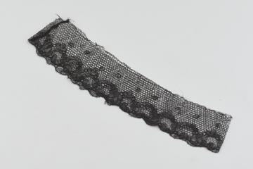 Piece of black border lace with scalloped edge