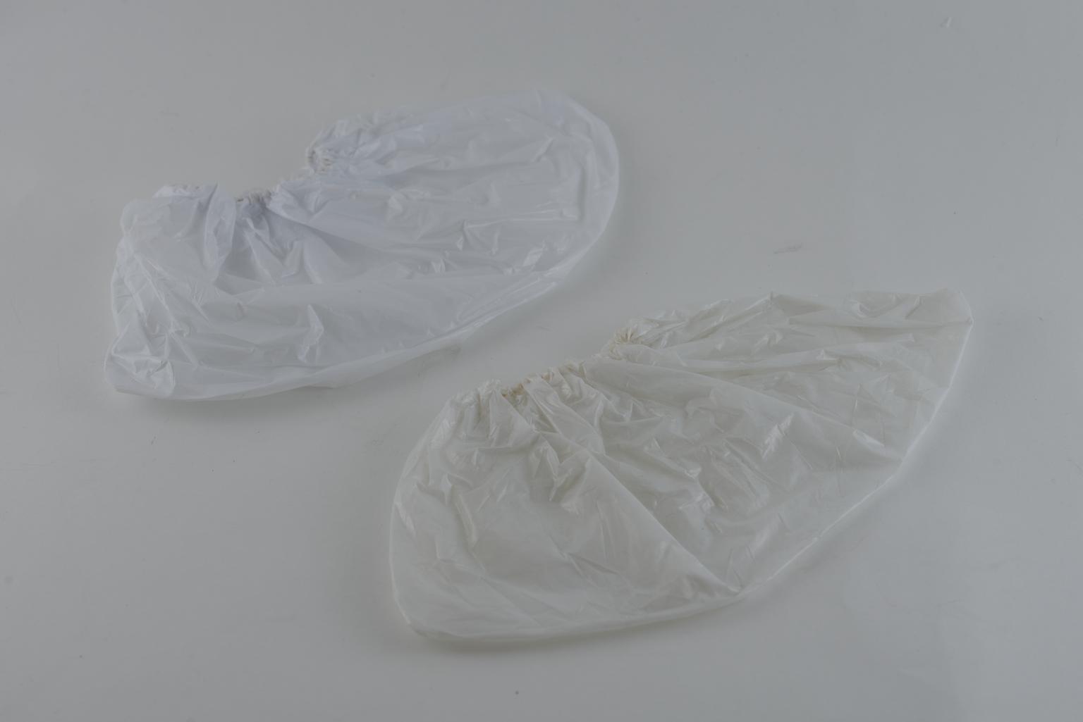 Pair of 3-ply disposable overshoes in tissue-polythene-tissue