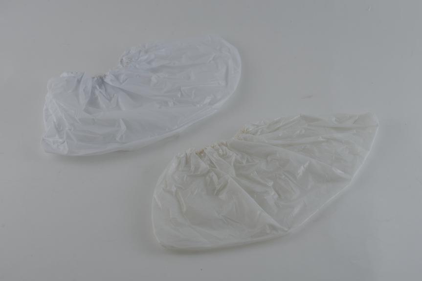 Pair of 3-ply disposable overshoes in tissue-polythene-tissue