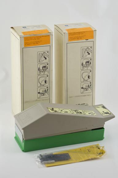 Two Draeger Parat escape masks both in wall containers; one open