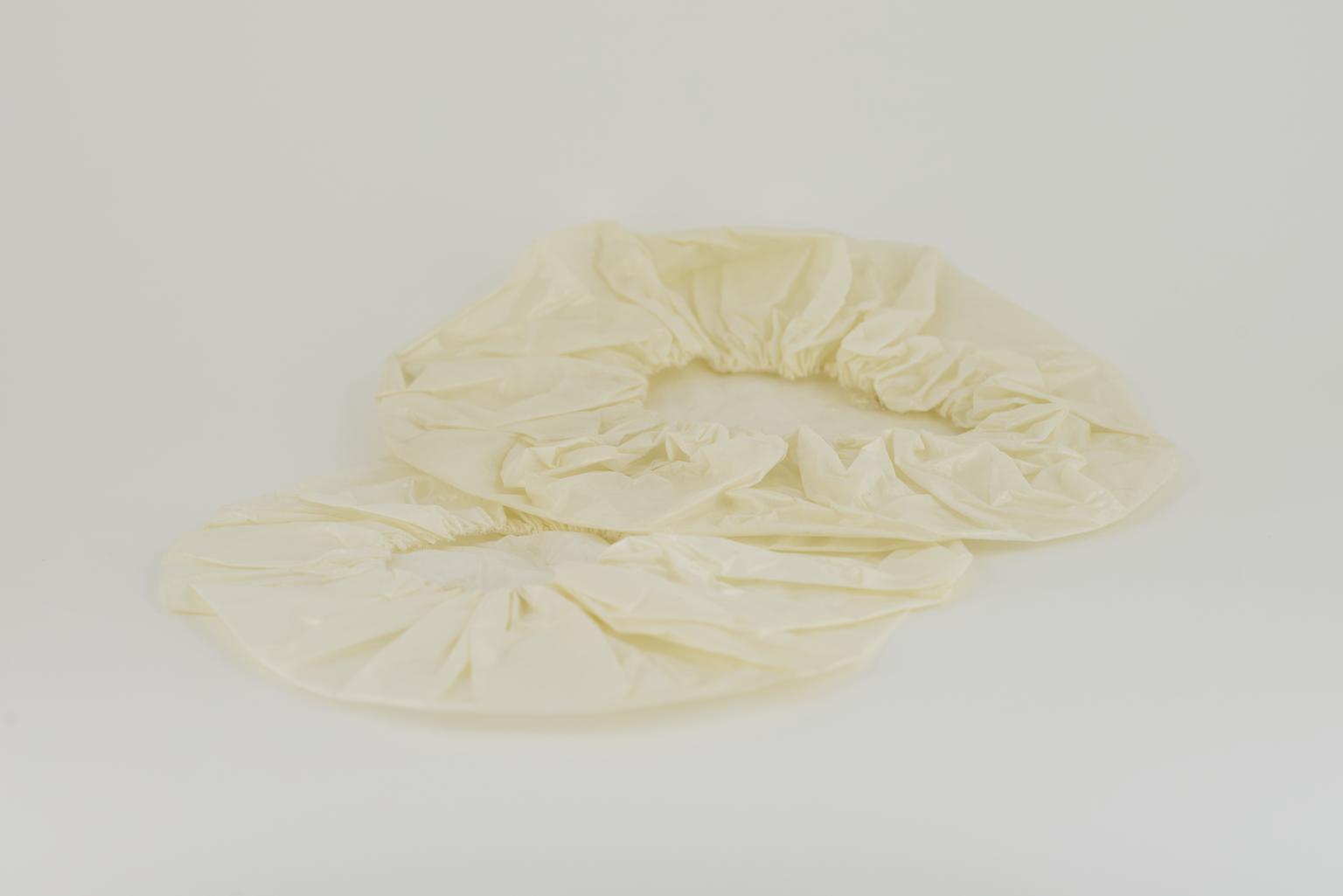 Two round hats in tissue-polythene-tissue