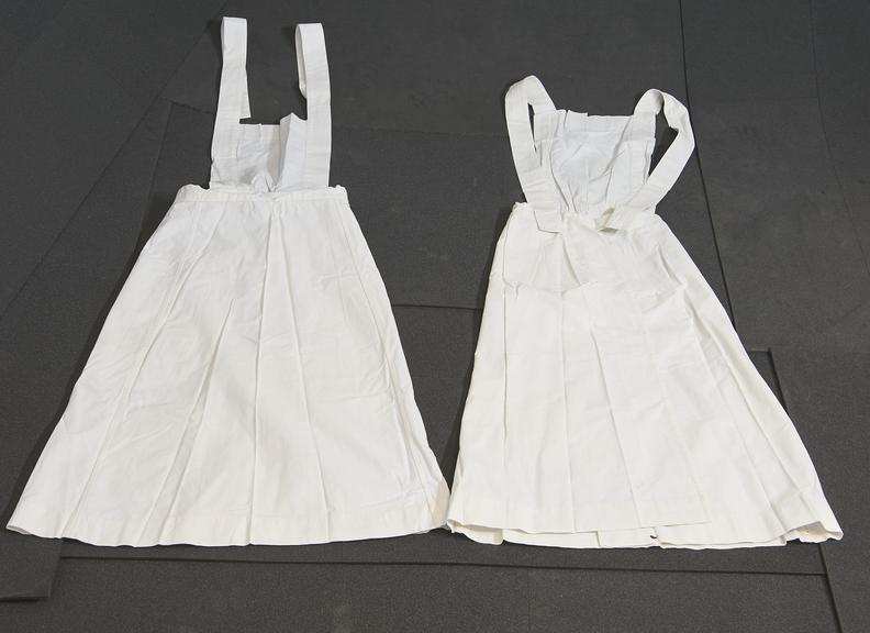 Two White Linen Aprons with Square Bibs and Cross Straps.