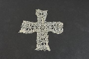 Piece of lace in form of a cross