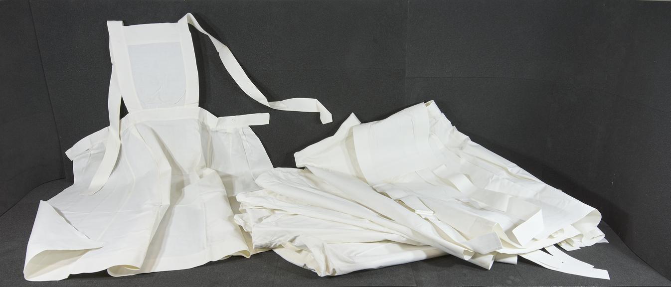 Seven SRN white linen aprons