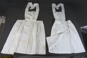 Two linen aprons with square bibs and cross-straps