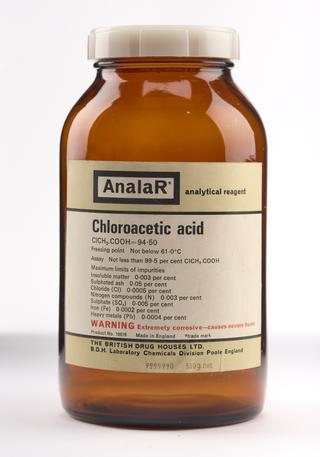 An empty brown glass bottle for chloroacetic acid.