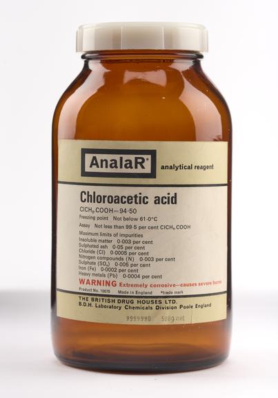 An empty brown glass bottle for chloroacetic acid.