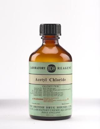 An empty brown glass bottle for acetyl chloride.