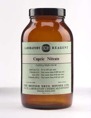 An empty brown glass bottle for cupric nitrate.