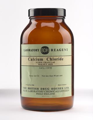 An empty brown glass bottle for calcium chloride.