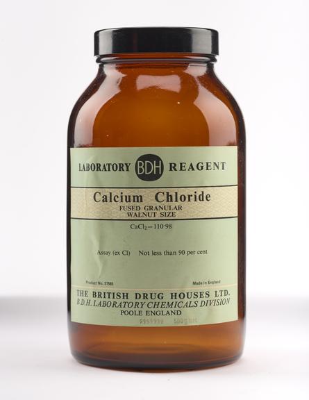 An empty brown glass bottle for calcium chloride.