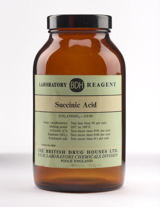 An empty brown glass bottle for succinic acid.