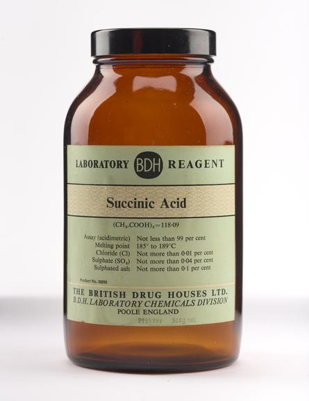 An empty brown glass bottle for succinic acid.