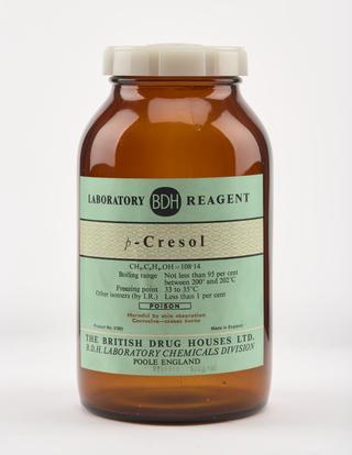 An empty brown glass bottle for p-cresol.
