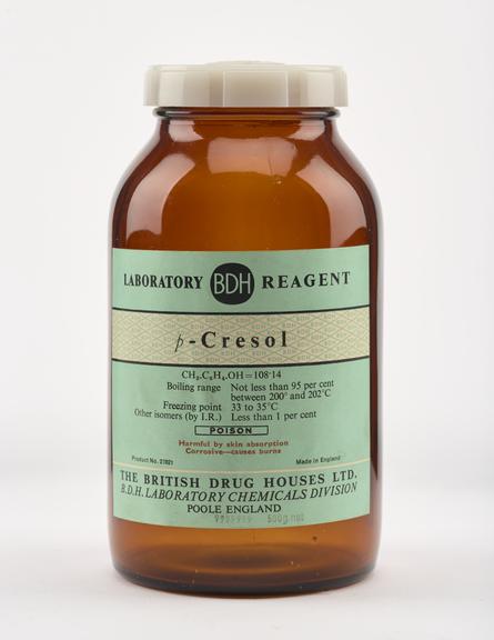 An empty brown glass bottle for p-cresol.