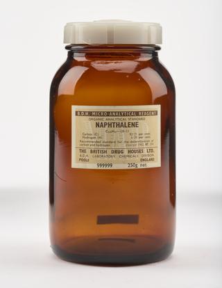 An empty brown glass bottle for naphthalene.
