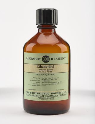 An empty brown glass bottle for ethanediol.