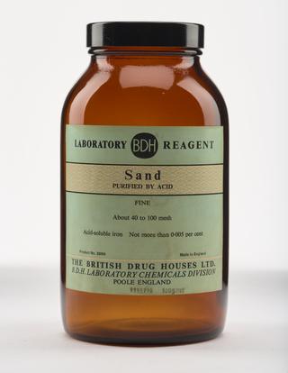 An empty brown glass bottle for sand.