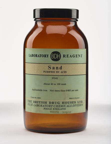 An empty brown glass bottle for sand.