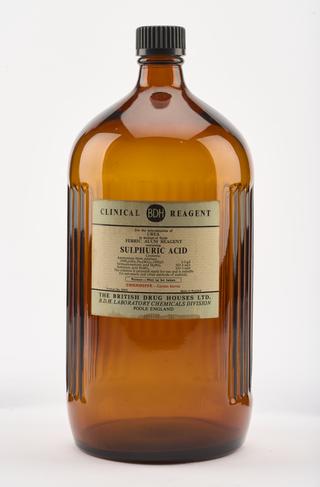 An empty brown glass bottle for sulphuric acid.