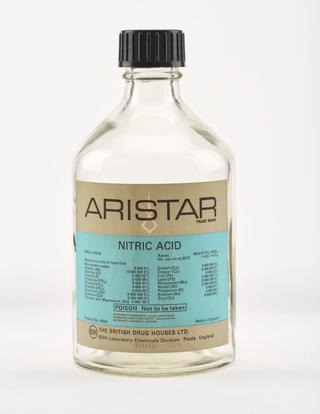 An empty clear glass bottle for nitric acid.