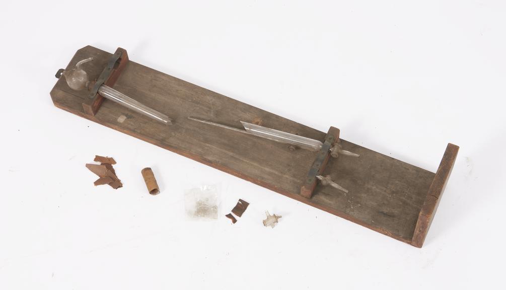 Two glass test tubes mounted on board