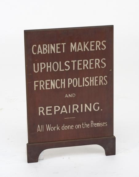 Polished shop sign with painted lettering