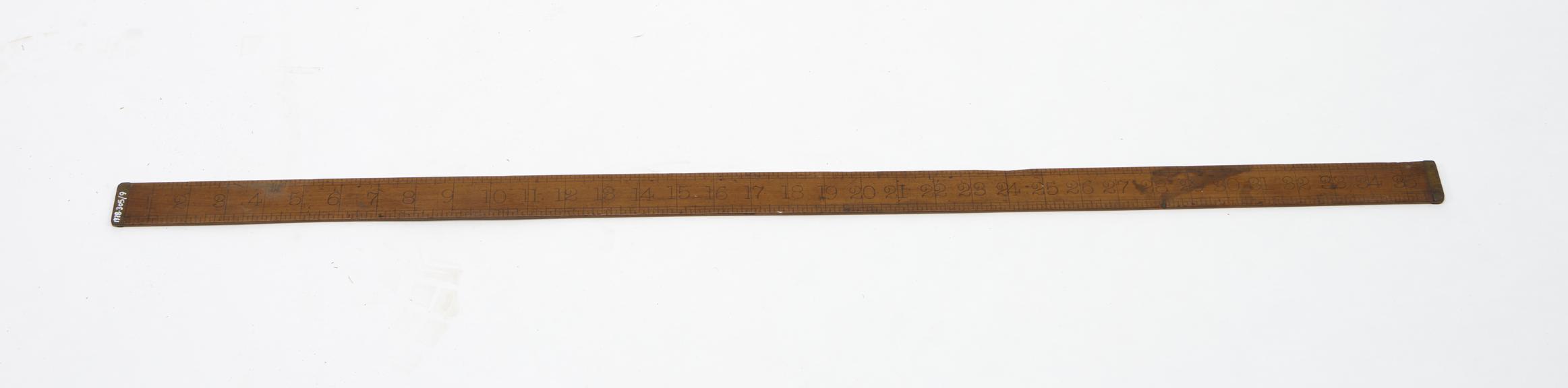 Wooden yard-stick shod with brass