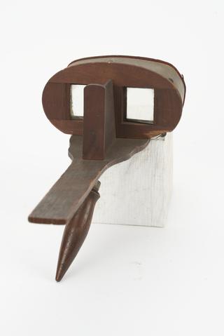 One handheld "mask" type stereoscopic viewer. Made of wood and lined in red velvet